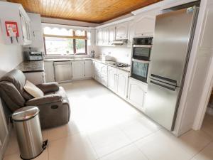 卡拉罗Aras Iosgan的厨房配有白色橱柜和不锈钢冰箱