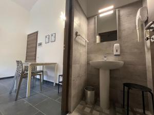 都灵Hostel Turin Metro Young的浴室配有水槽和桌椅