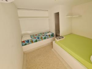 阿沃莱特斯El Faro Hostel的小房间设有绿色和白色的床