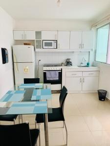 通苏帕Casa del mar的厨房配有白色橱柜和蓝色的桌椅