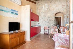 里奥托尔托Appartamento Palmaiola的一间厨房,配有红色橱柜和一台电视机