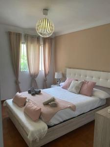 贝纳尔马德纳Chalet adosado corta temporada 2 dormitorios的卧室配有带粉红色枕头的大型白色床