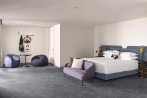 圣地亚哥Kimpton Alma San Diego, an IHG Hotel的一间卧室配有一张床和一张紫色椅子