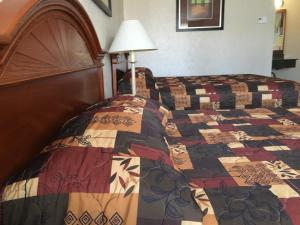 格伦斯福尔斯地标汽车旅馆的一间卧室配有床,床上装有被子