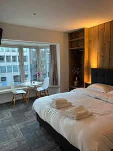 布鲁日Prachtige kamer in centrum Brugge met badkamer !的卧室配有一张床和一张桌子及椅子