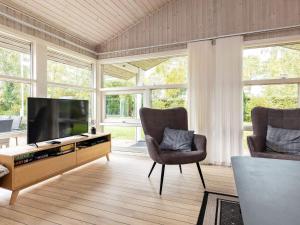 奥特鲁普Holiday home Otterup XVIII的客厅配有2把椅子和平面电视