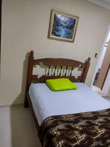 安格拉杜斯雷斯Hospedagem da Val的一间卧室配有一张带黄色枕头的木床