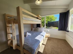哈海Hahei Magic的一间卧室设有两张双层床和一扇窗户。