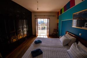 明德卢Guest House Montanha的一间卧室配有一张带两个蓝色枕头的床
