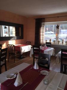 Kirkel阿喀琉斯酒店的一间带桌椅的用餐室和窗户。
