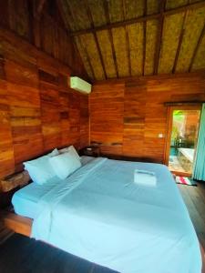 乌鲁瓦图绿碗海滩别墅的木墙客房的一张床位