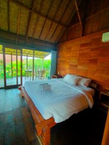 乌鲁瓦图绿碗海滩别墅的一间卧室设有一张带木墙的大床