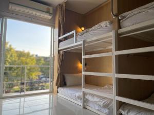 清迈普太的旅舍的客房设有双层床和带阳台的窗户。