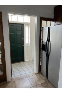 查尔斯顿Grand Old White Capitol Executive Suite的厨房设有绿门和冰箱。