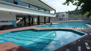 哥打丁宜Desaru Brown House Pool-Table Tennis-KTV-BBQ-Netflix-Home Theatre的大楼前的大型游泳池