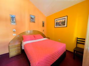 奇瓦伊Rumi Wasi的一间卧室配有橙色墙壁的床