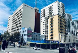 珀斯Wallaby Backpackers Hostel Perth - note - Valid passport required to check in -的一座有高楼和有车的街道的城市