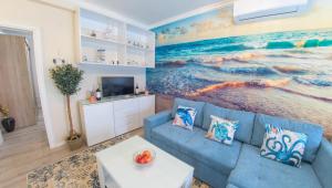 莫斯塔尔Luka-Mostar Free Parking的客厅配有蓝色的沙发和海洋绘画