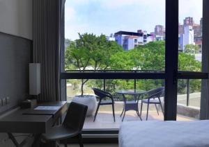 新店白金花园酒店的酒店客房,配有一张床、一张桌子和椅子