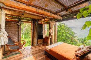 卡朗阿森Bird Hills Bamboo House的一间卧室设有一张床和一个大窗户
