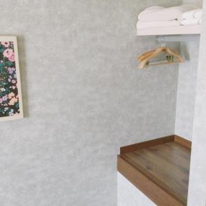 洲本市アパートメントホテル Mimoza的浴室拥有白色的墙壁和带毛巾的架子。