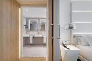 马拉加NH马拉加酒店的一间卧室,配有带水槽的浴室和一张床