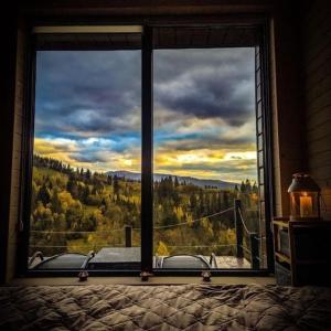 斯拉夫西克Ecottage котедж для двох у горах із чаном-джакузі的卧室窗户享有森林美景