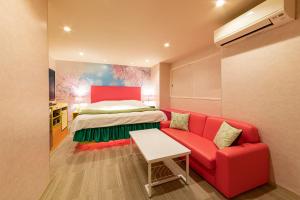 天理市Koriyama Flower Style的红色的沙发和客房内的一张床
