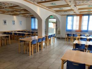 英格堡Engelberg Youth Hostel的空的饭厅,配有桌椅