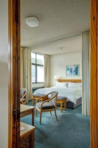 开普敦花园中心假日公寓酒店的酒店客房带一张床、一张桌子和椅子