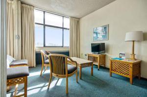 开普敦花园中心假日公寓酒店的酒店客房带一张床、一张桌子和椅子