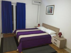 察夫塔特Villa Royal的一间卧室设有两张床和蓝色窗帘
