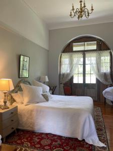 马奇The Coach House on River and Park的卧室配有一张白色大床和吊灯。
