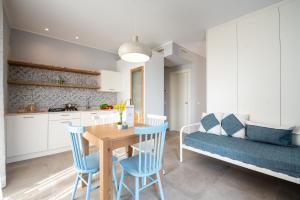 锡罗洛Dietro L'angolo Appartamenti的厨房以及带桌子和蓝色椅子的用餐室。