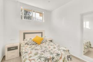 马拉加MILLION APARTAMENT的白色卧室配有一张带黄色枕头的床