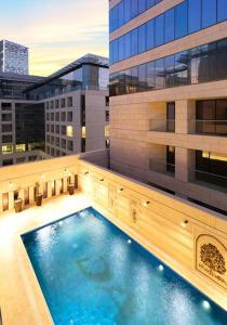 安曼Al Fares Luxury furnished Apartment-Damac Tower的大楼一侧的大型游泳池
