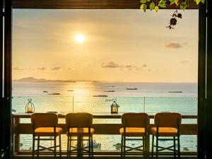 芭堤雅市中心Mytt Hotel Pattaya - SHA Extra Plus的桌椅,享有海景