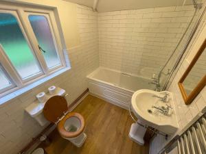 布罗肯赫斯特Historic 2 bed gatehouse in private parkland的浴室配有卫生间、盥洗盆和浴缸。