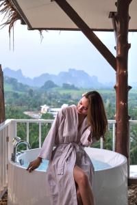 奥南海滩Baan Phuvara Retreat - Romantic Jacuzzi Mountain View Villas的坐在浴缸里的女袍子