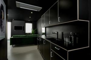 伦敦基普酒店的厨房配有黑色橱柜和绿色沙发
