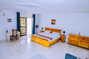 基加利Nature Kigali的一间卧室配有木床和木制梳妆台