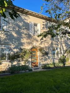 Location maison à Chadron : Haute Loire的白色的房子,有门和草地庭院