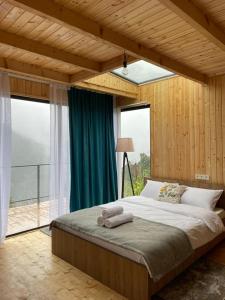 Kʼveda ChʼkhutunetʼiHouse in mountains, near Batumi- Lemanor Lodge的一间卧室设有一张大床和大窗户