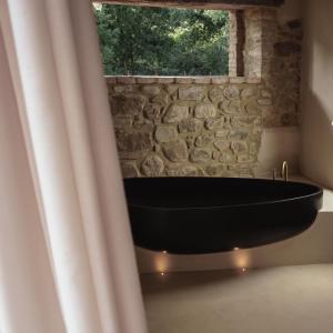 CalzolaroVocabolo Moscatelli的石墙客房内的浴缸