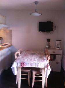 吕兹-圣索沃尔STUDIO AVEC BALCON的客房设有桌椅、桌子和电视。