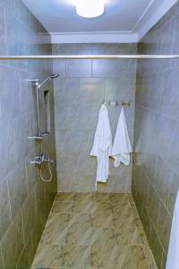 基加利Nature Kigali的浴室设有淋浴,墙上配有白色毛巾