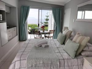 西蒙镇德拉希尔克里玛特旅馆的一间卧室设有一张大床,享有海景