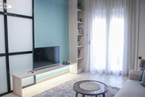 科莫蒂尼CasaTu Αpartments的客厅配有电视、沙发和桌子