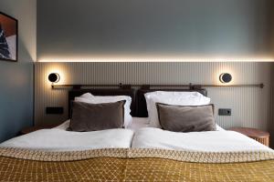卡尔斯塔德Elite Stadshotellet Karlstad, Hotel & Spa的一间卧室配有两张带白色床单和枕头的床。