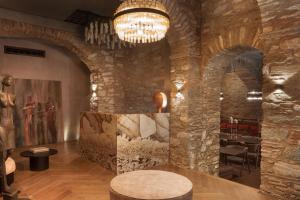 埃尔莫波利斯Castro Hotel Syros的大堂设有大型石墙和吊灯